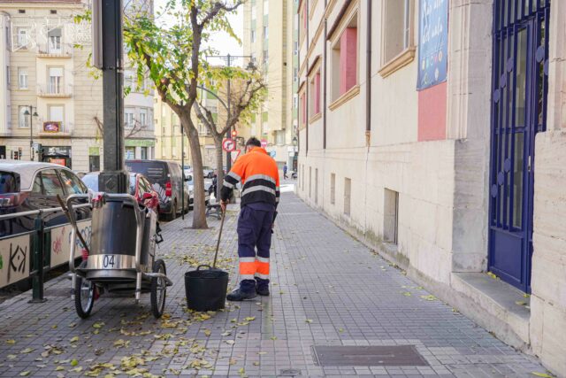 Un operari agrana manualment els carrers d'Alcoi