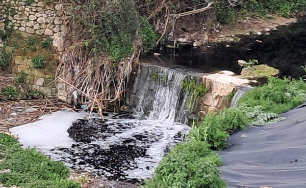 El riu Riquer, amb les aigües ennegrides per la contaminació que denúncia la Colla Ecologista La Carrasca a Alcoi